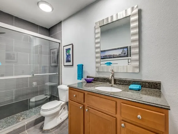 a bathroom with a granite countertop sink toilet and shower