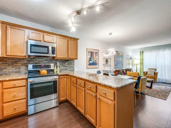 a kitchen with stainless steel appliances granite countertop a stove sink microwave and cabinets