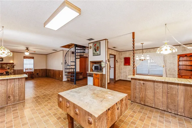 a living room with furniture a flat screen tv and kitchen view