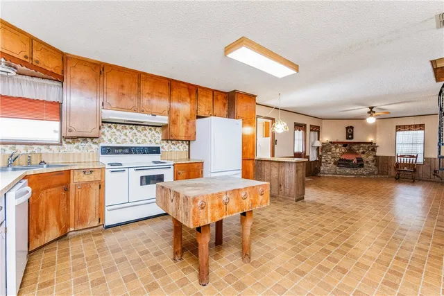 a kitchen with stainless steel appliances granite countertop a stove a sink dishwasher and a refrigerator