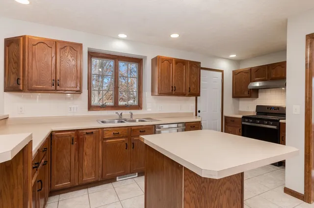 a kitchen with a stove a sink a microwave and cabinets