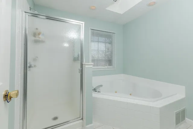 a white bath tub sitting next to a shower
