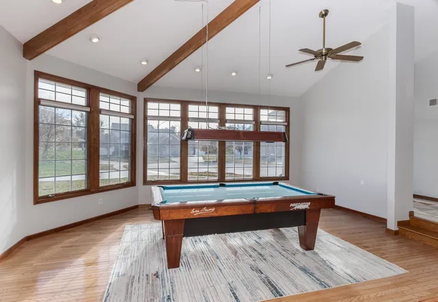 a room with pool table and windows