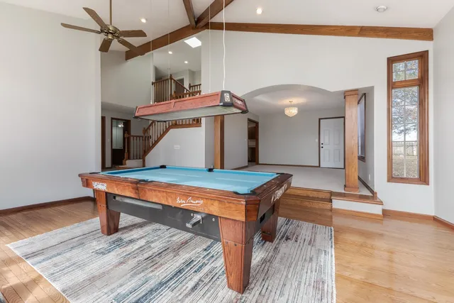 a room with pool table and windows