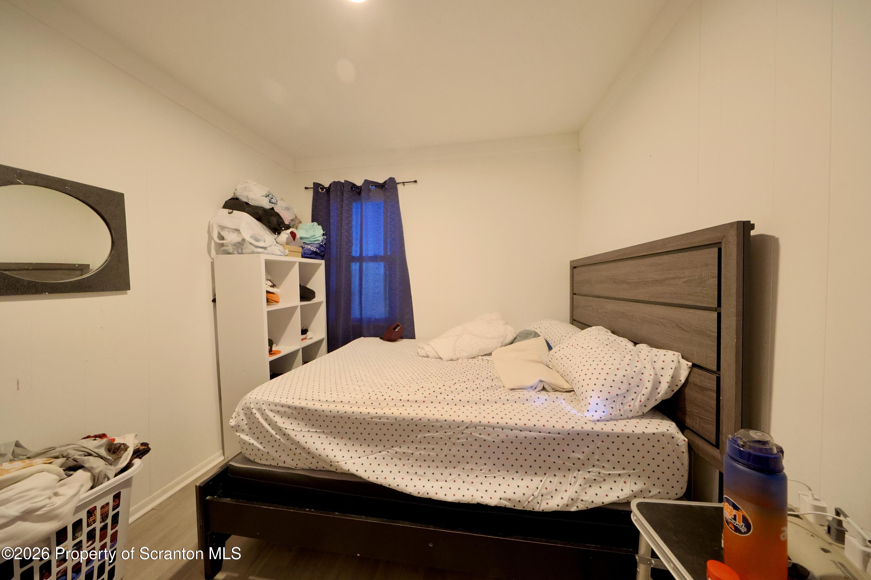 1016-1018 Diamond Avenue Scranton, PA 18508 - Photo 8 of 15 a bed sitting in a bedroom next to a window with tv