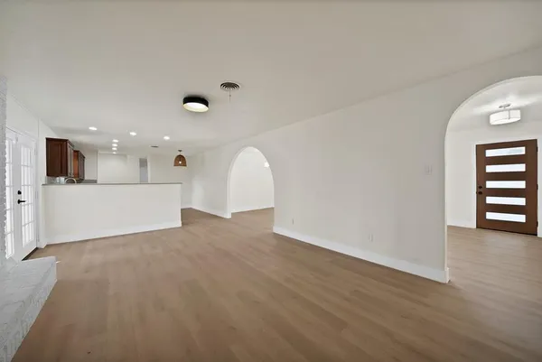 a view of a big room with wooden floor and windows