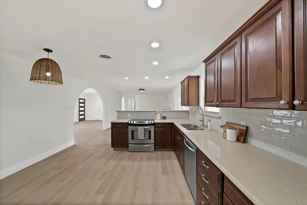 a kitchen with stainless steel appliances granite countertop a sink stove and refrigerator