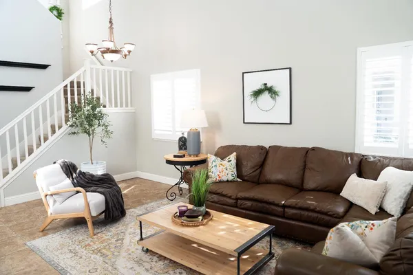 a living room with furniture a rug and a chandelier