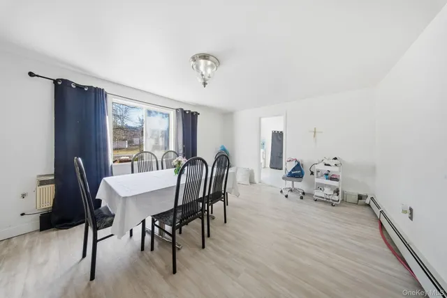 a view of a a dining room with furniture window and wooden floor