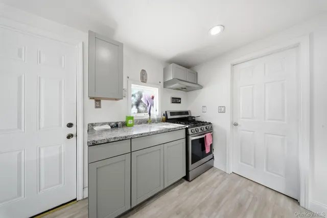 a kitchen with stainless steel appliances granite countertop a sink and a stove top oven