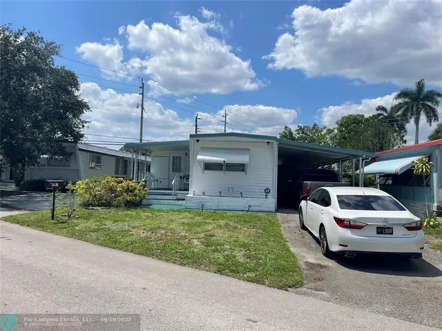 a white house covered with tall trees