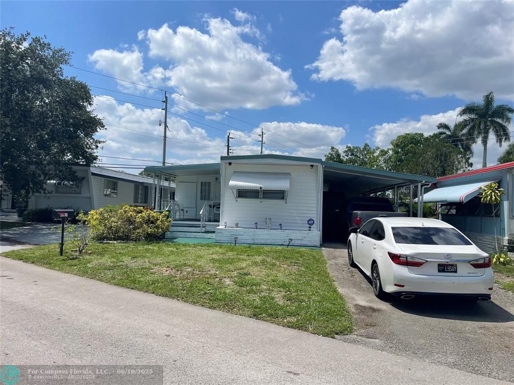 a white house covered with tall trees