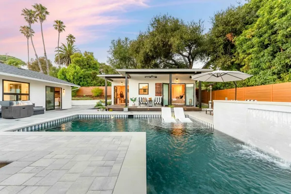 a view of a house with backyard and sitting area