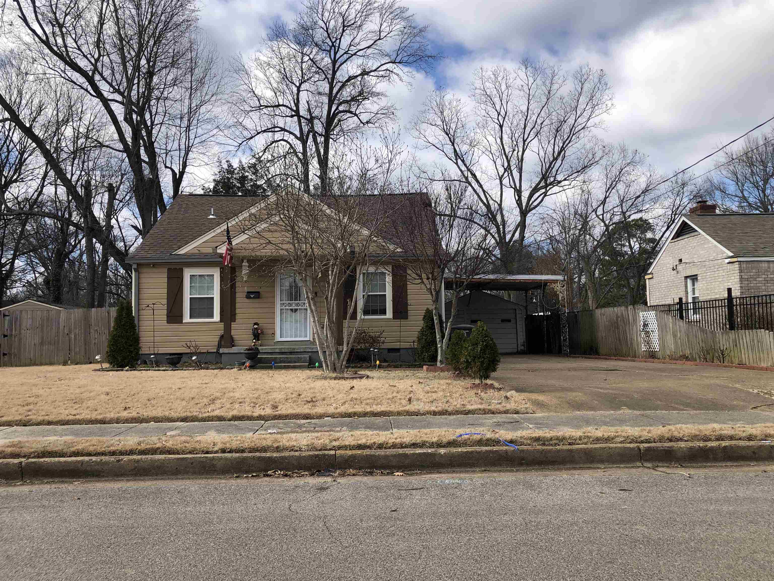 a front view of a house with a large trees