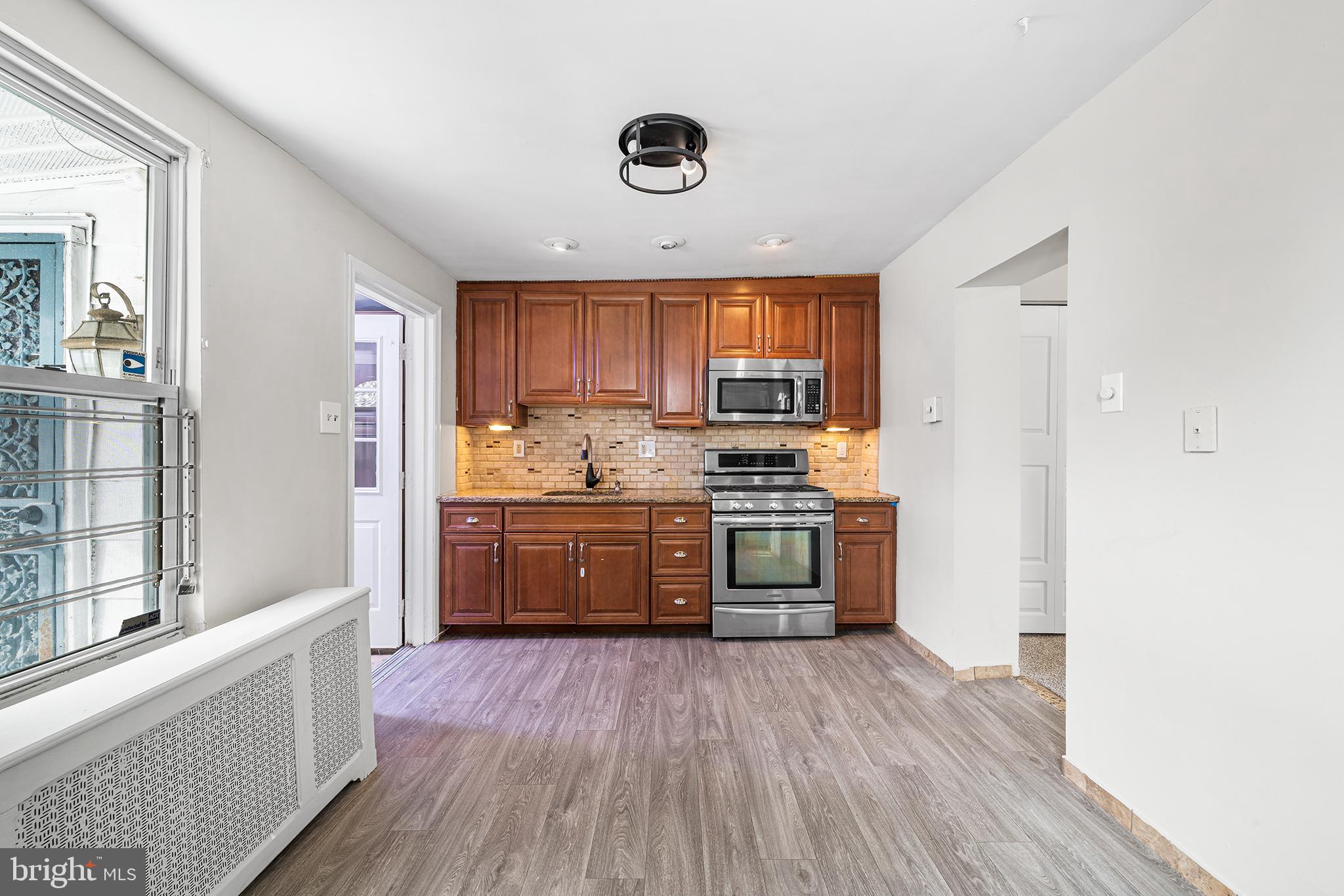 1006 Highland Avenue Chester, PA 19013 - Photo 14 of 29 a kitchen with stainless steel appliances a refrigerator a sink dishwasher stove and oven with wooden floor