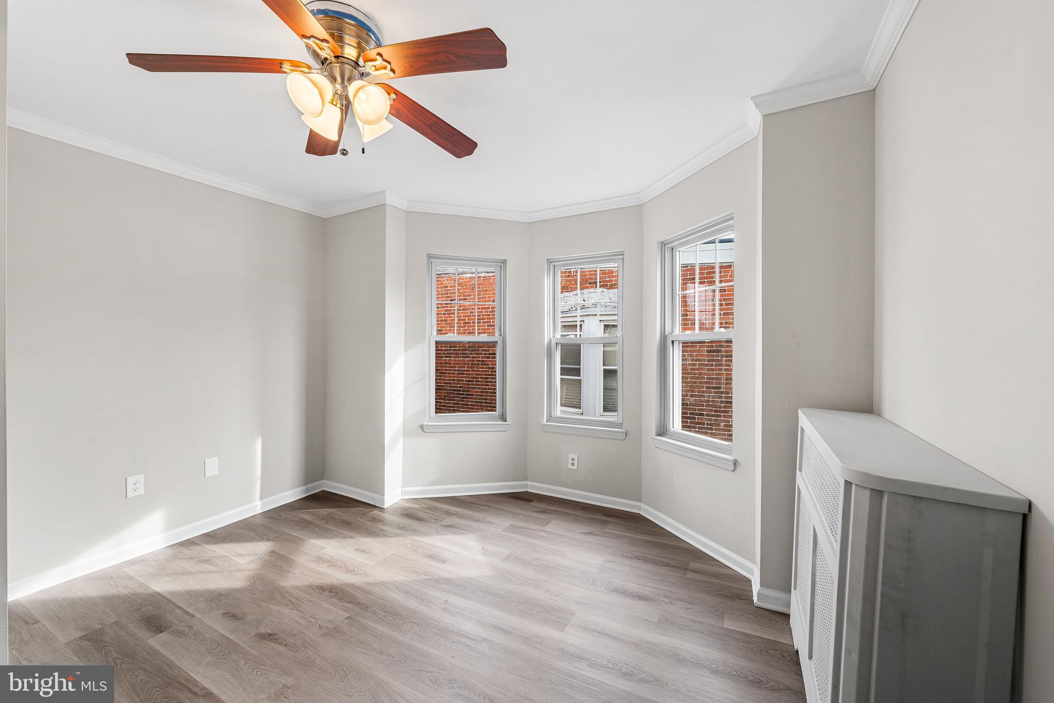 1006 Highland Avenue Chester, PA 19013 - Photo 20 of 29 an empty room with wooden floor chandelier fan and windows