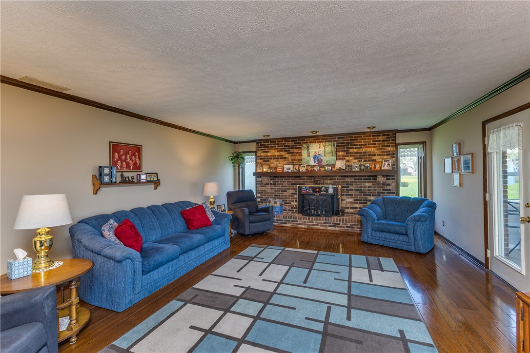 4210 Pleasanton Road Englewood, OH 45322 - Photo 13 of 34 This living area features rich hardwood flooring and a classic brick fireplace.
