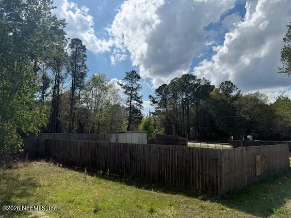 a view of backyard with wooden fence