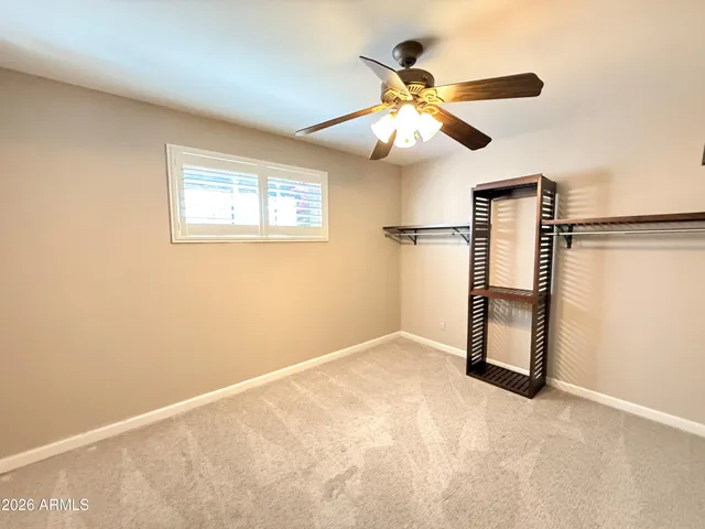 an empty room with windows and fan
