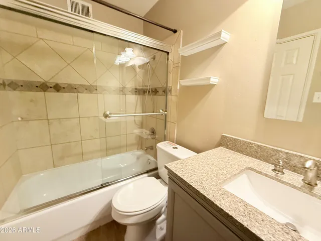 a bathroom with a granite countertop sink toilet and shower