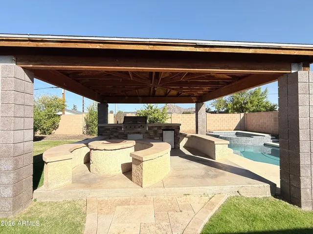 a view of a patio with table and chairs a barbeque with wooden fence