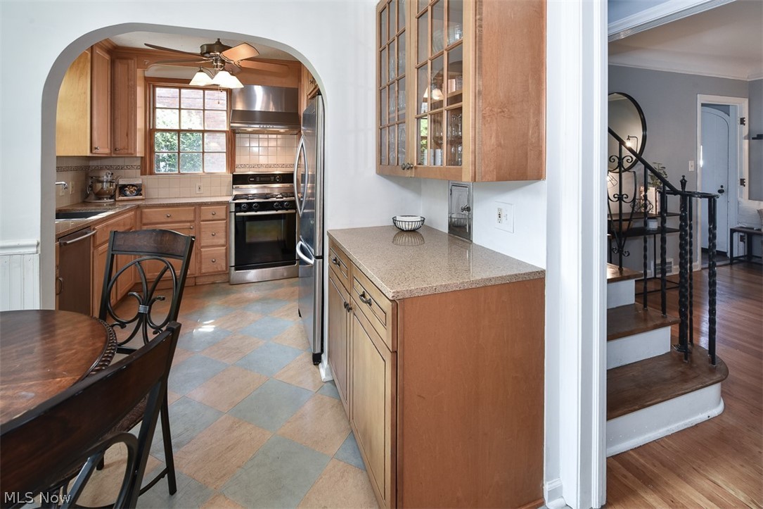 2559 Channing Road Cleveland, OH 44118 - Photo 5 of 28 Kitchen with ceiling fan, stainless steel appliances, light wood-type flooring, wall chimney exhaust hood, and backsplash