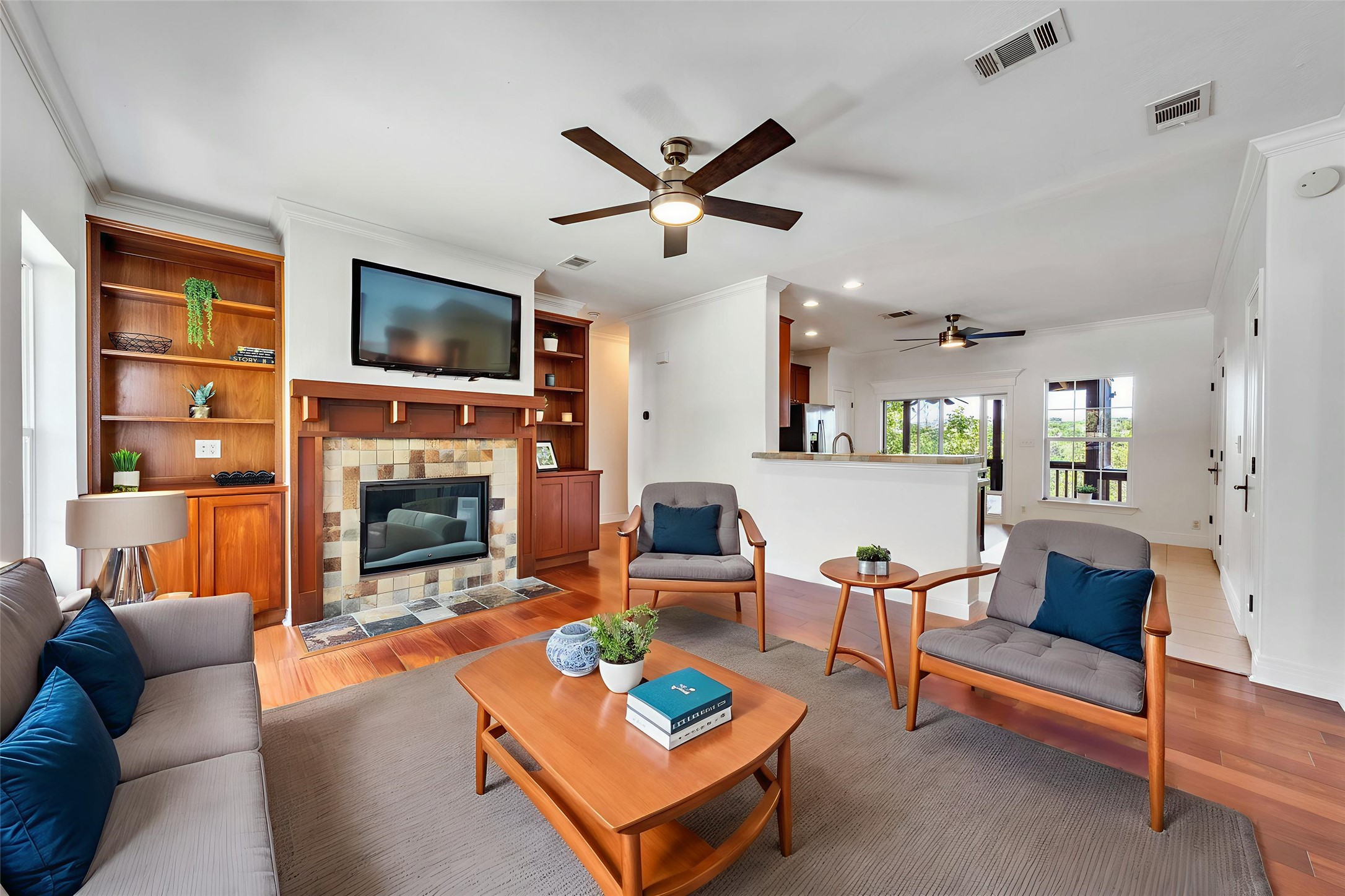 2108 Indian Creek Road Austin, TX 78734 - Photo 2 of 40 Living room with crown molding, light wood-style flooring, a tile fireplace, ceiling fan, and recessed lighting