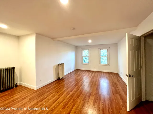 a view of a room with wooden floor and window