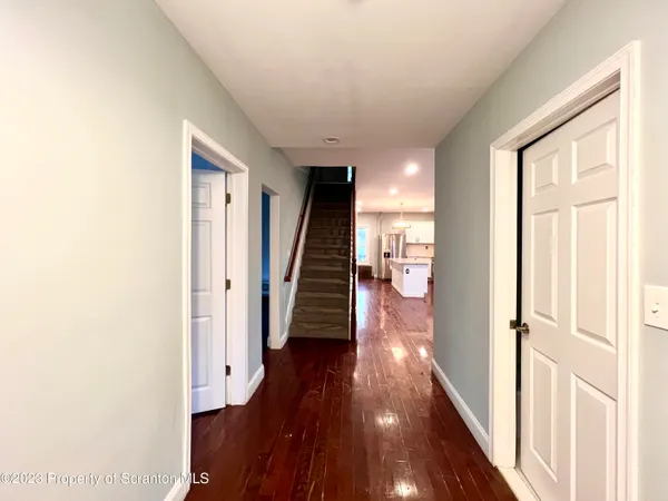 a view of a hallway with wooden floor and staircase