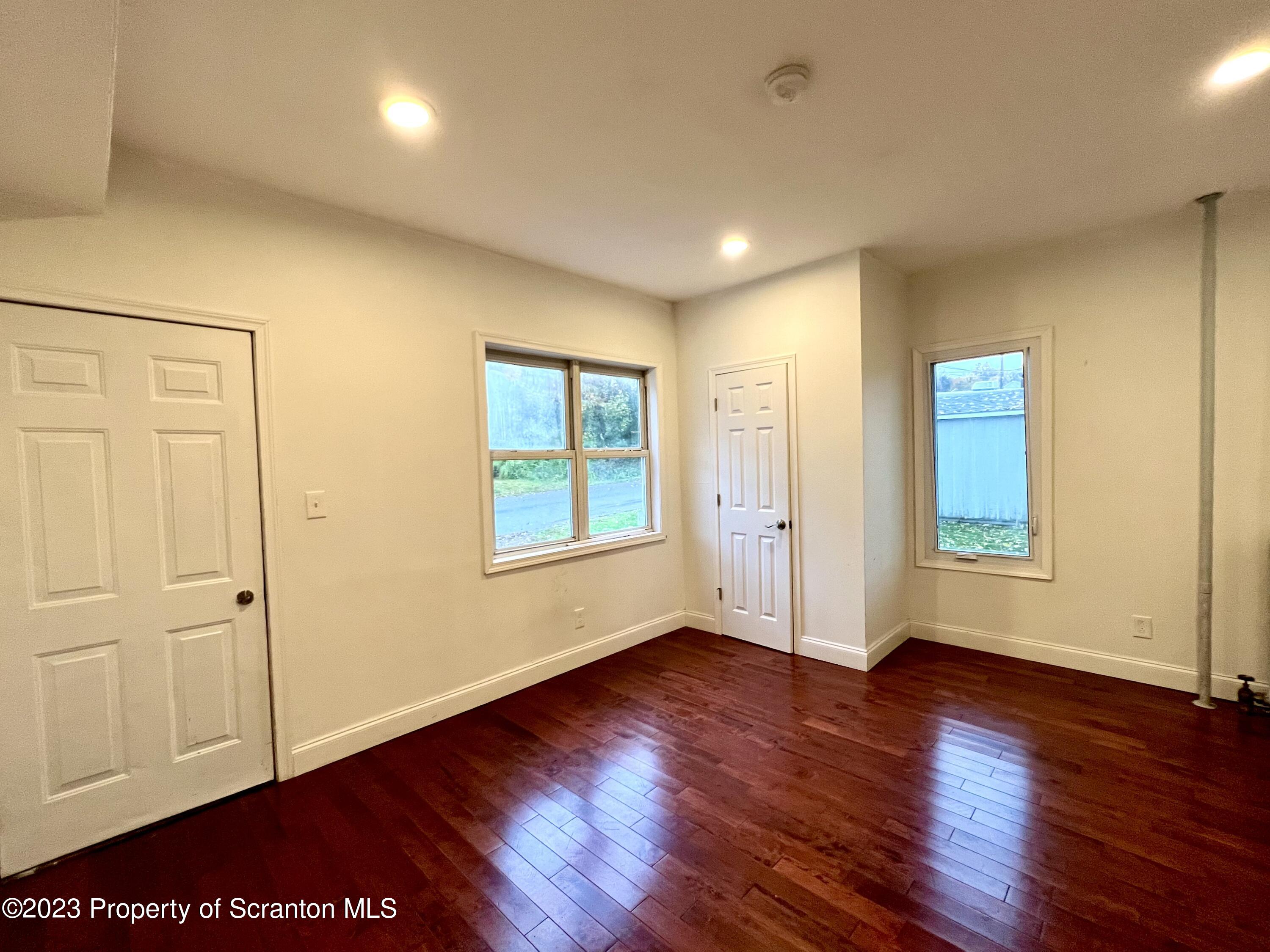 1109 Grove Street Avoca, PA 18641 - Photo 3 of 17 an empty room with wooden floor and windows