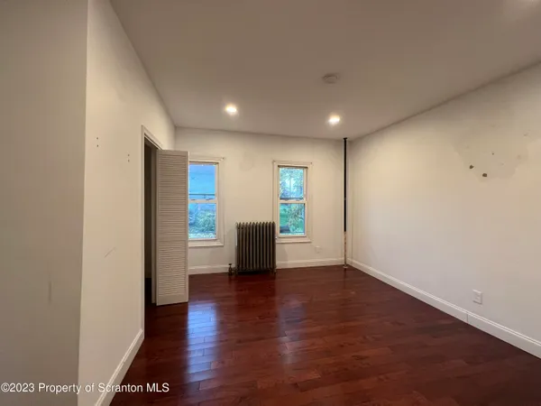 a view of empty room with wooden floor