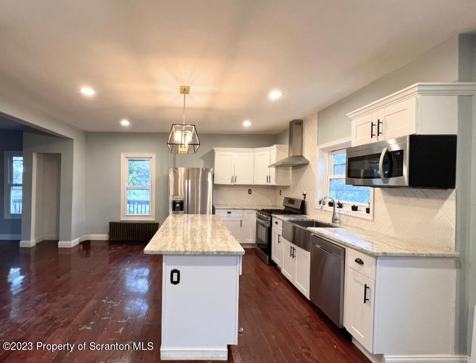 1109 Grove Street Avoca, PA 18641 - Photo 5 of 17 a large kitchen with stainless steel appliances kitchen island granite countertop a large stove a sink dishwasher and white cabinets with wooden floor
