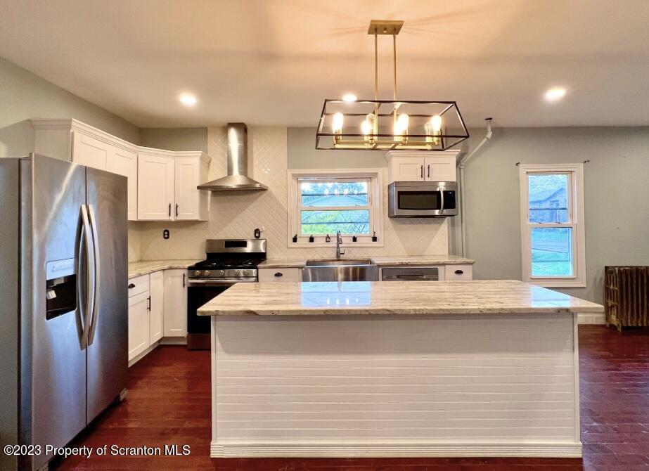 1109 Grove Street Avoca, PA 18641 - Photo 6 of 17 a kitchen with kitchen island granite countertop a refrigerator a stove a oven a sink dishwasher and wooden floor
