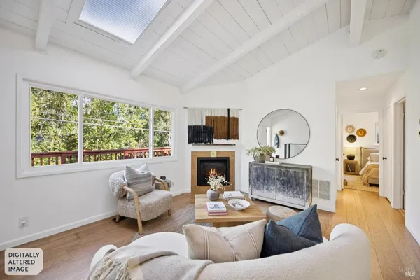 a living room with furniture fireplace and a large window
