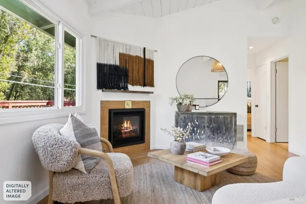 a living room with furniture fireplace and a large window