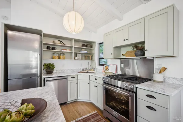 a kitchen with stainless steel appliances granite countertop a stove a sink and a refrigerator