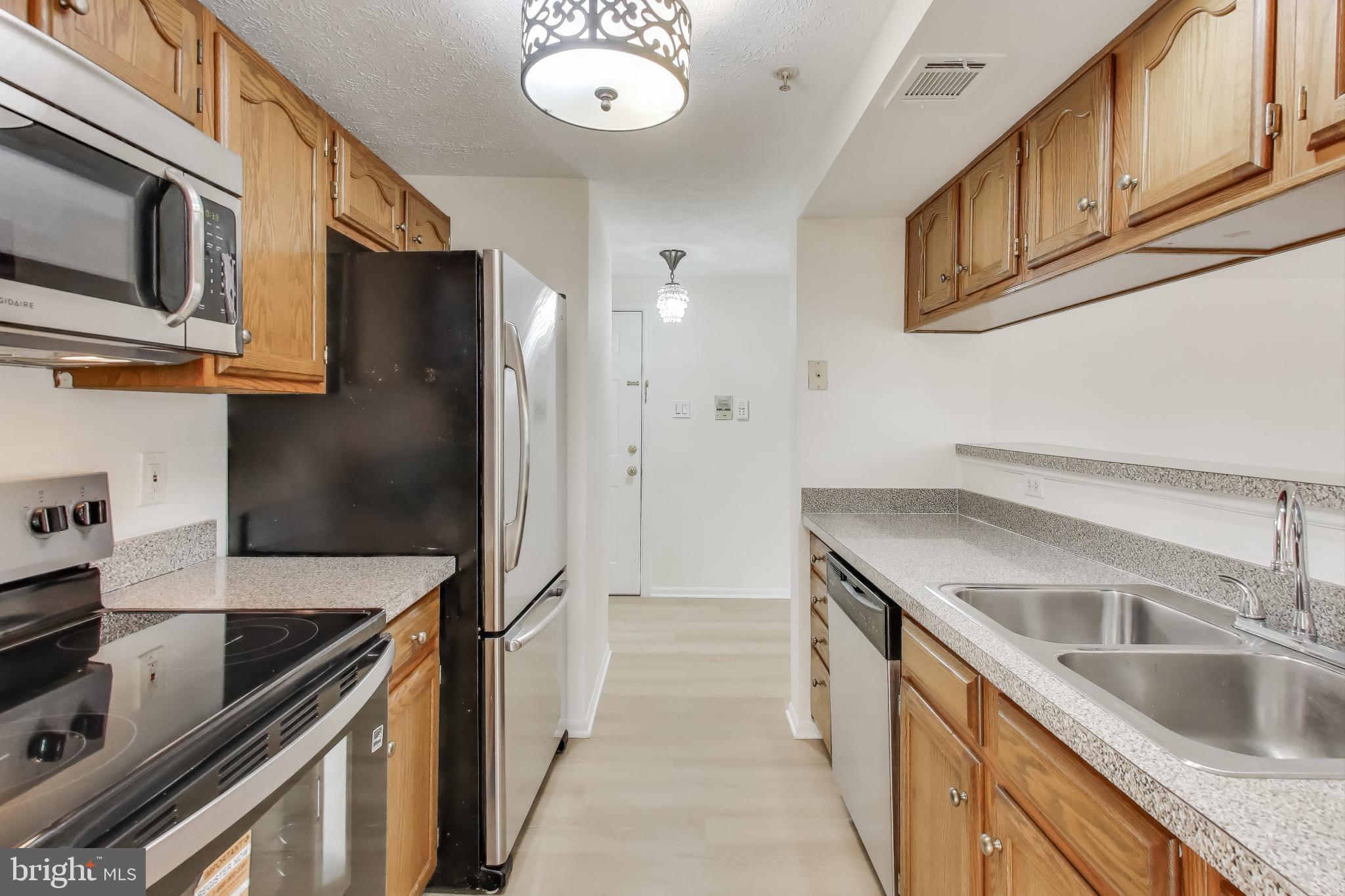 13107 Briarcliff Terrace, Unit 2204 Germantown, MD 20874 - Photo 12 of 30 a kitchen with stainless steel appliances granite countertop a sink and a refrigerator