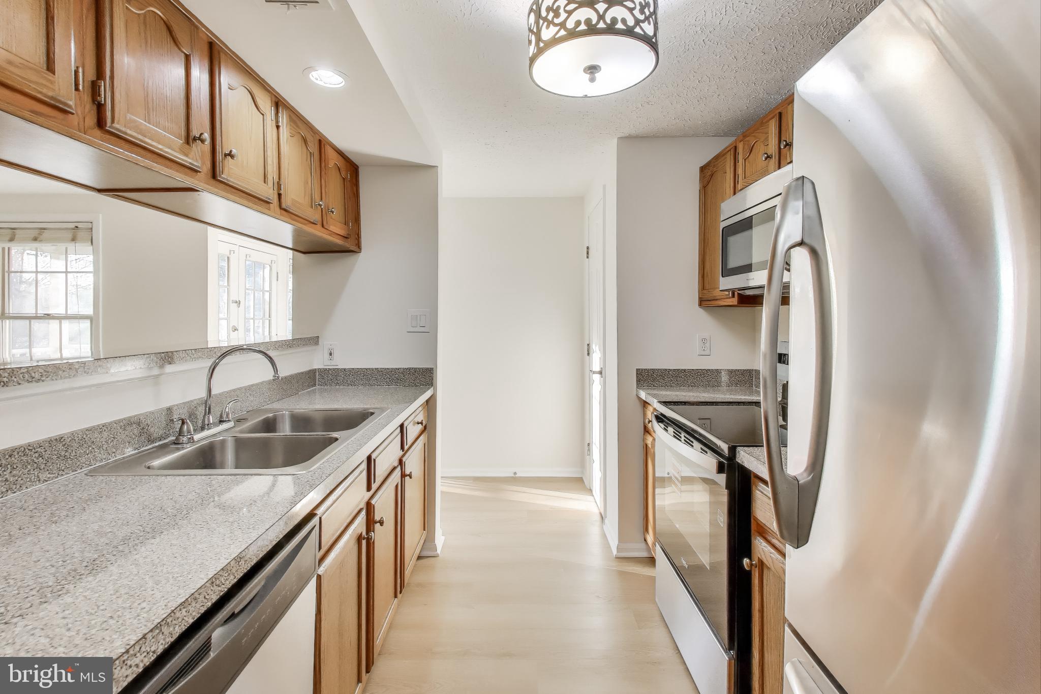 13107 Briarcliff Terrace, Unit 2204 Germantown, MD 20874 - Photo 13 of 30 a kitchen with stainless steel appliances granite countertop a sink and a refrigerator