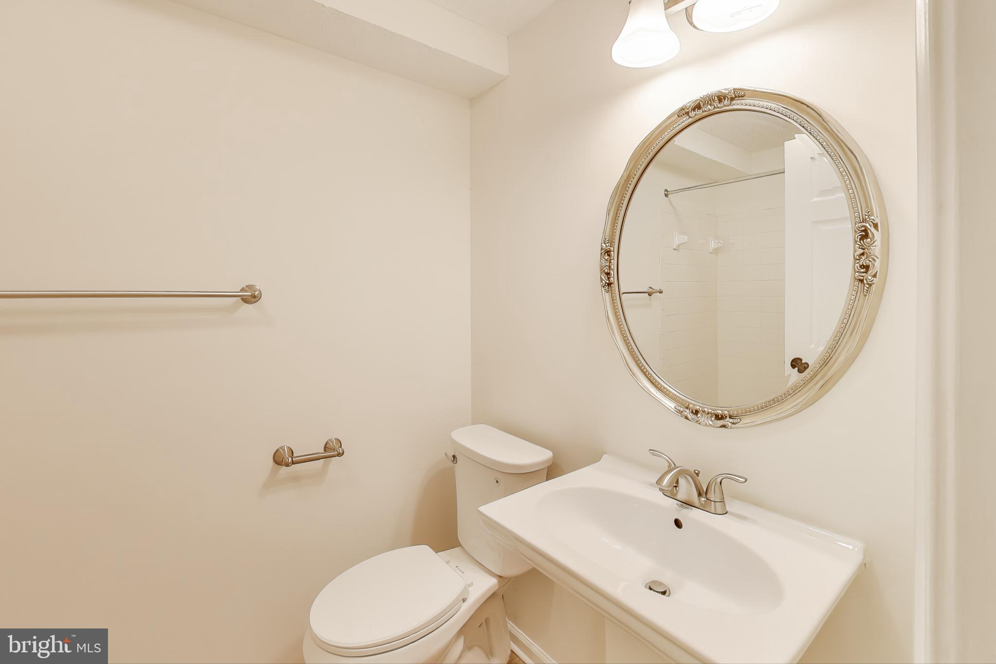13107 Briarcliff Terrace, Unit 2204 Germantown, MD 20874 - Photo 23 of 30 a bathroom with a sink mirror and toilet