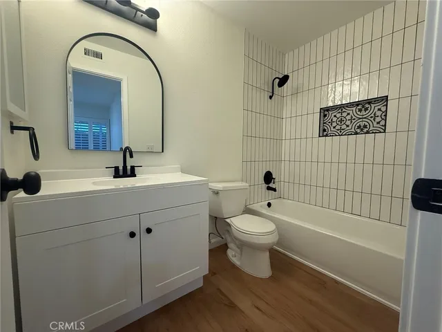 a bathroom with a toilet a sink a mirror a bathtub and shower