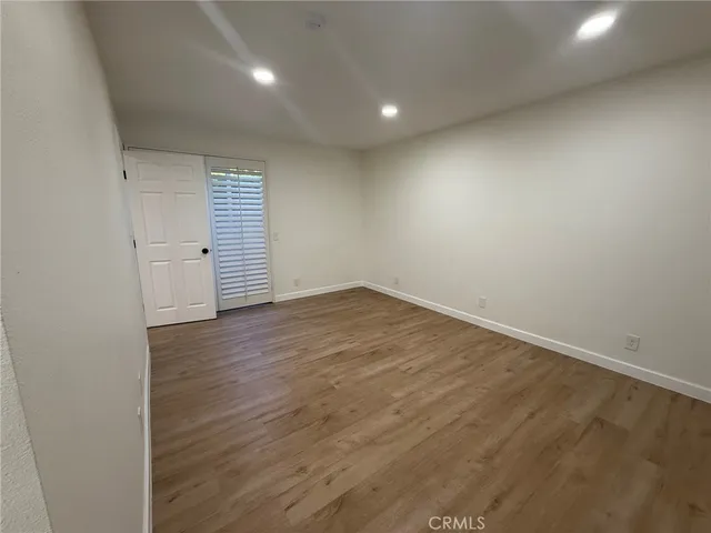 an empty room with wooden floor and white walls