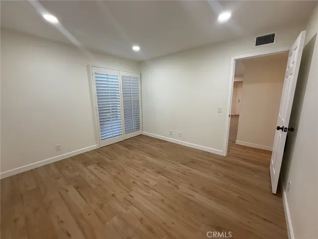 an empty room with wooden floor and white walls