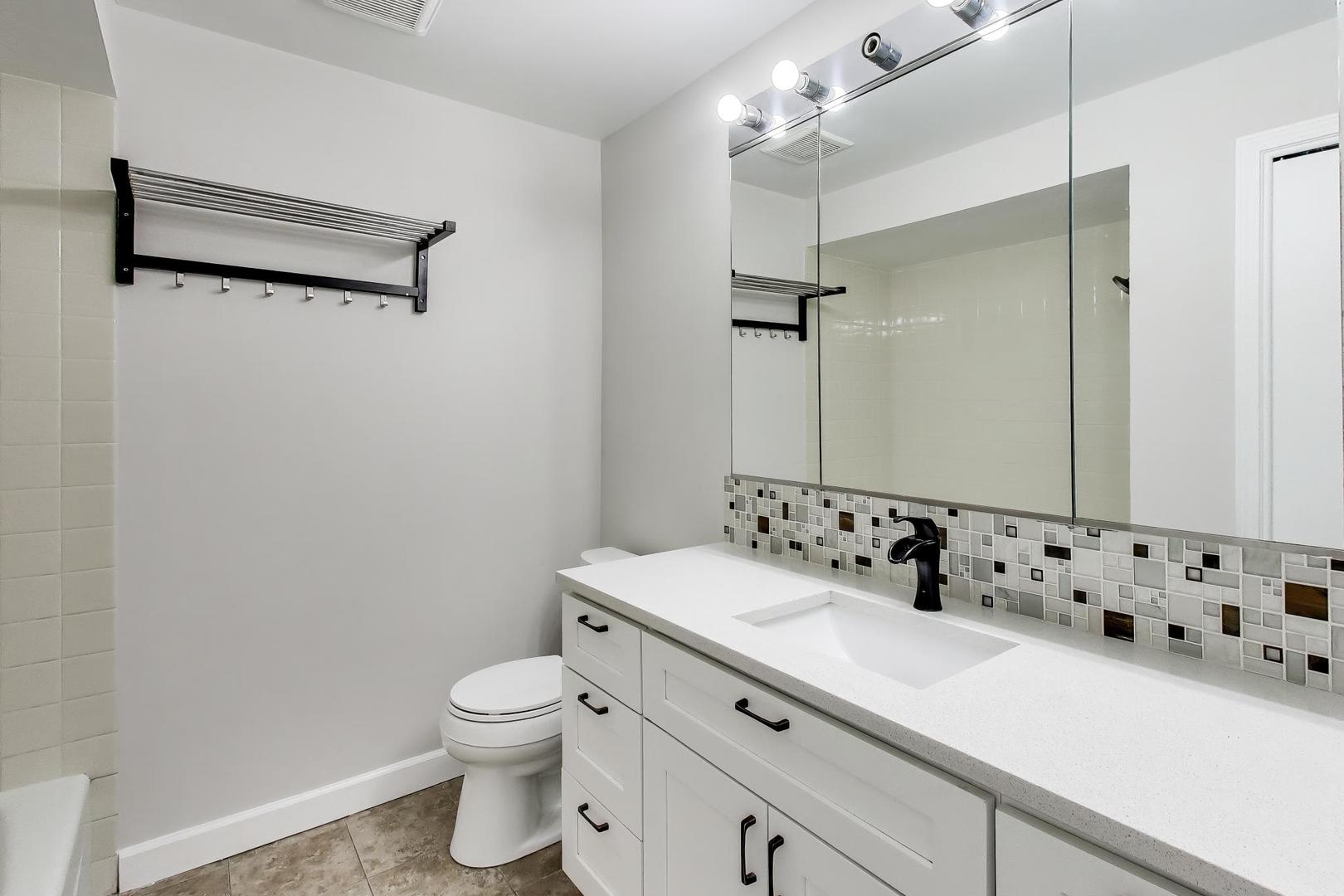 8610 Waukegan Road, Unit 302 Morton Grove, IL 60053 - Photo 22 of 34 a bathroom with a sink a toilet and shower