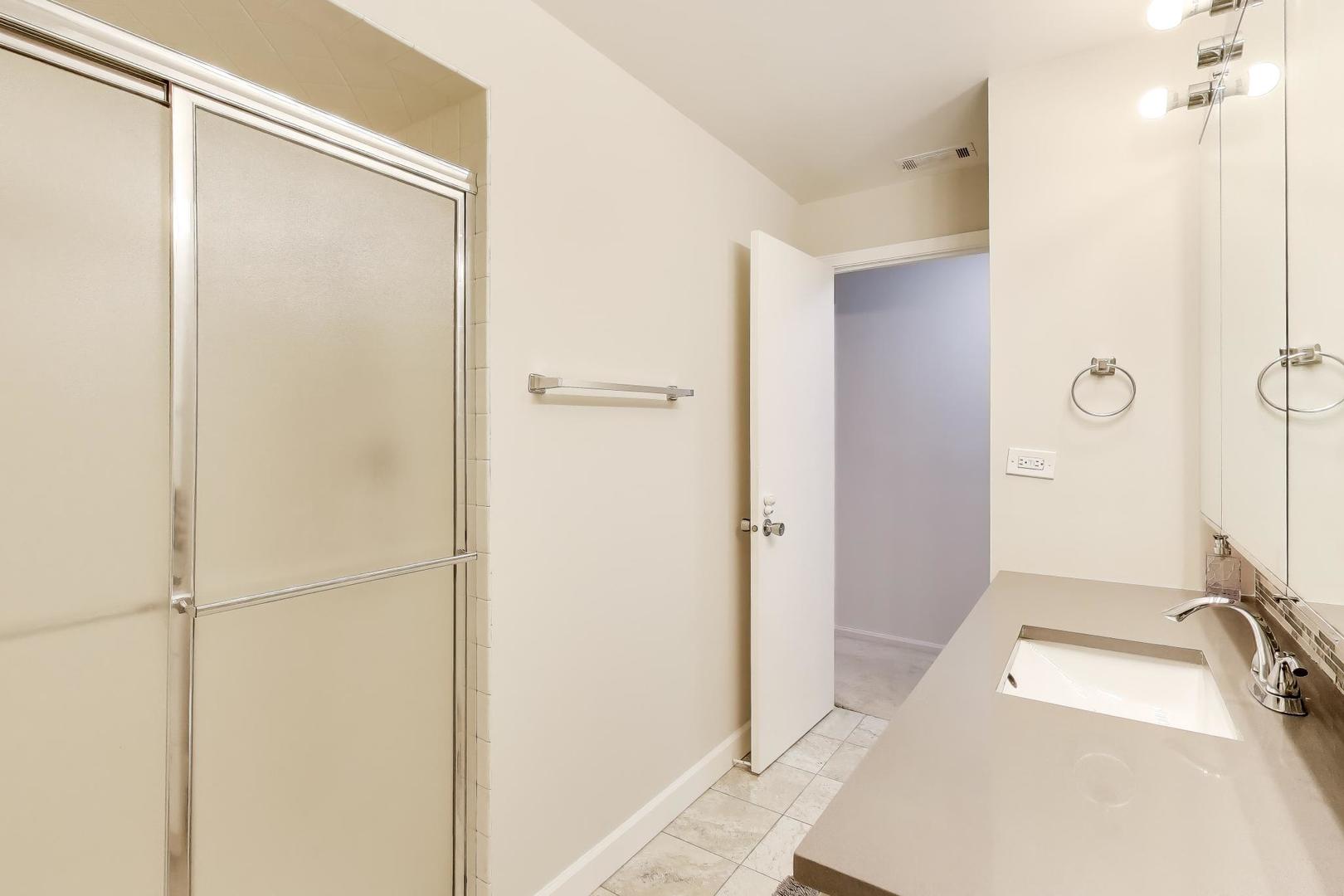 8610 Waukegan Road, Unit 302 Morton Grove, IL 60053 - Photo 29 of 34 a bathroom with a sink and a mirror