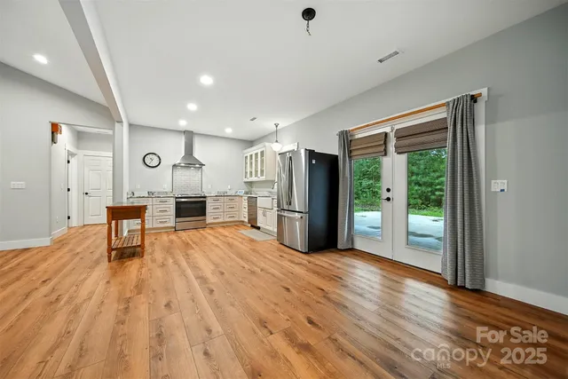 a view of empty room with wooden floor and window