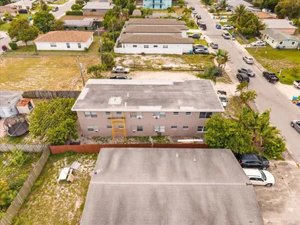 aerial view of a house with a yard and large trees