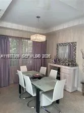a dining room with furniture and a floor to ceiling window