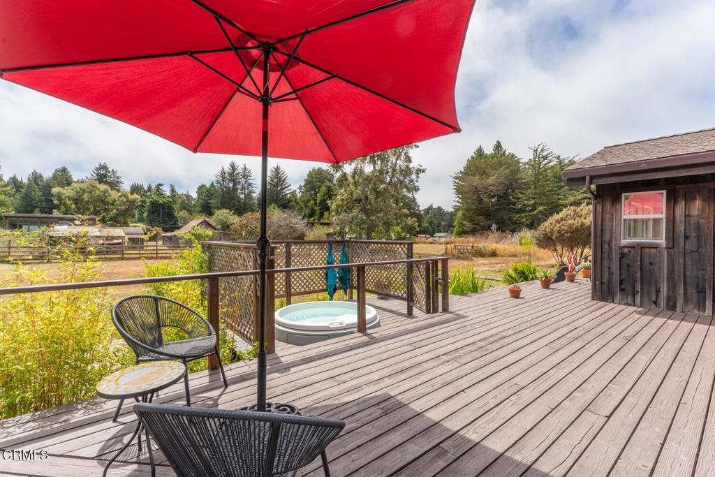 30470 Pudding Creek Road Fort Bragg, CA 95437 - Photo 20 of 34 a view of a roof deck with dining table and chair under an umbrella with wooden floor