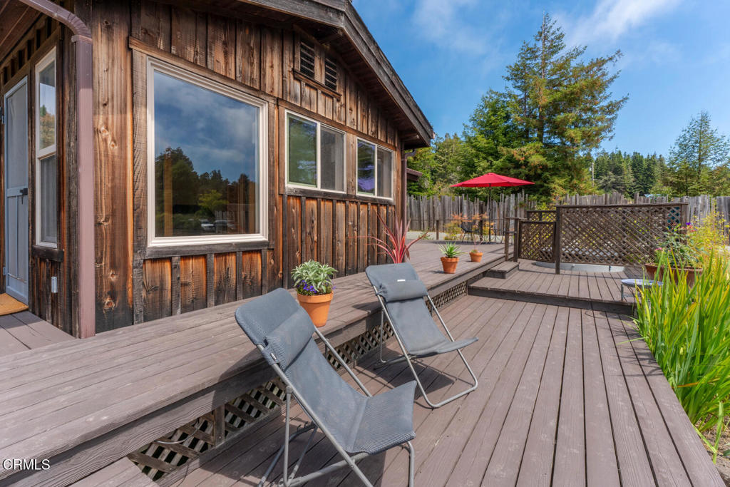 30470 Pudding Creek Road Fort Bragg, CA 95437 - Photo 21 of 34 a view of a patio with table and chairs with wooden floor and fence