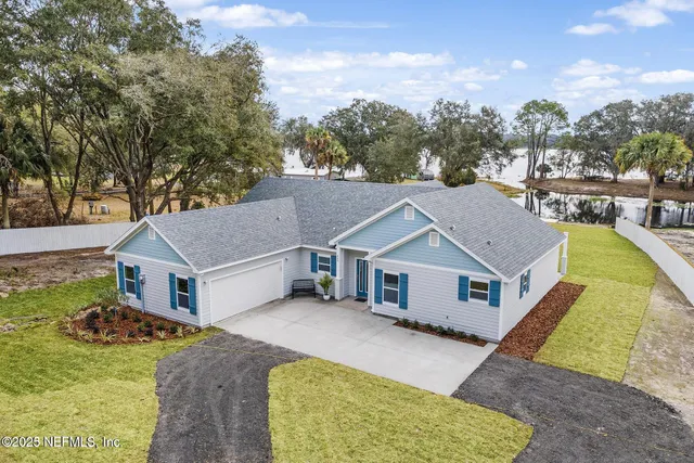 a aerial view of a house next to a big yard and large trees
